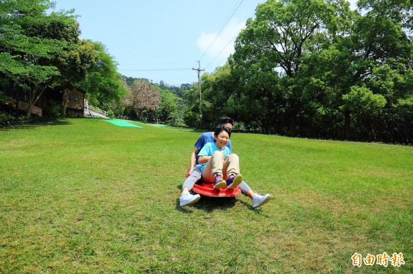刺激又好玩的滑草深受大人小孩喜愛，並設有自動回送滑草車的裝置，讓人不用拖著車爬坡。（記者李惠洲攝）