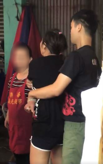 一名情緒激動的黑衣女子持刀在樂華夜市裡追砍飲料店男子，被眾人制伏。（圖擷取自爆料公社）