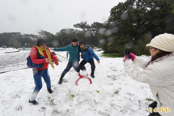 陽明山二子坪也都降下大雪，停車場處處積雪，民眾興奮與雪人合照。（記者劉信德攝）