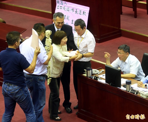 台北市議會16日進行「市長施政報告」,國民黨議員拿道具表達訴求。(記者方賓照攝)