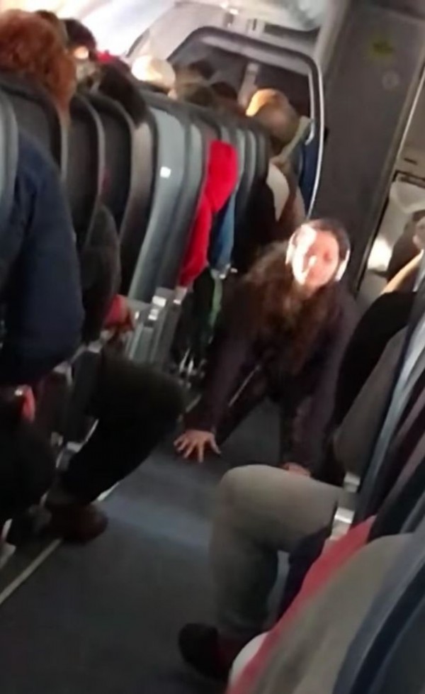 一名外國女子在飛機走到上大練瑜珈,不少乘客看傻眼。(圖擷自Mirror) 一名外國女子在飛機走到上大練瑜珈,不少乘客看傻眼。(圖擷自Mirror)