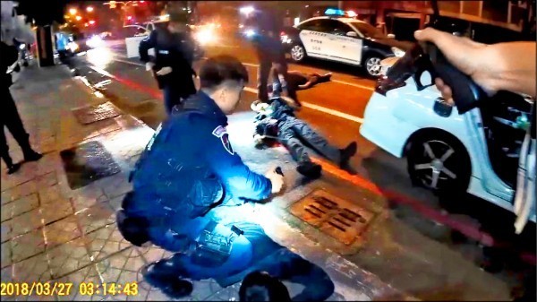 高雄街頭警匪槍戰，歹徒拔槍、警方駁火影片曝光，警方拉出中彈的通緝犯陳祈安急救。（記者黃良傑翻攝）