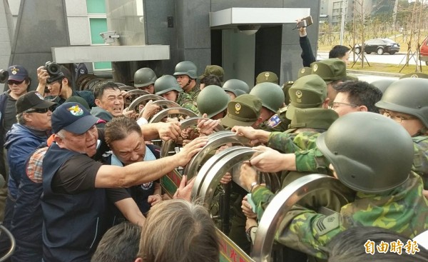 逾50名退伍軍人不滿蔡英文政府年金改革方案,聚集在國防部大門口抗議,並丟擲煙霧彈、雞蛋、撒冥紙,甚至試圖將國防部大門搖倒。(記者方賓照攝)