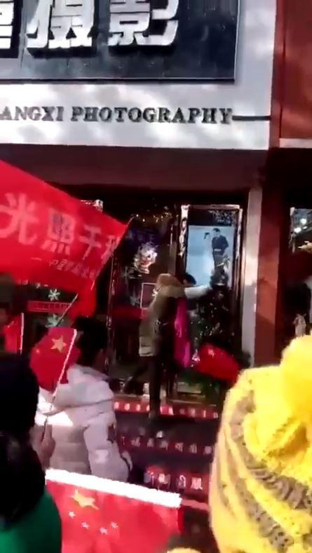 有大媽強扯店家門前的耶誕樹,害得整棵樹差點「身首分離」。(圖翻攝自影片)