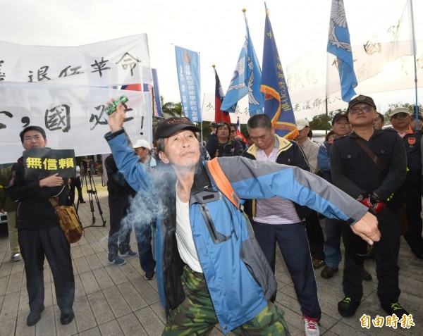 逾50名退伍軍人不滿蔡英文政府年金改革方案,聚集在國防部大門口抗議,並丟擲煙霧彈、雞蛋、撒冥紙,甚至試圖將國防部大門搖倒。(記者方賓照攝)