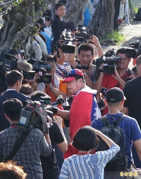 民眾披國旗引起騷動。(記者方賓照攝)