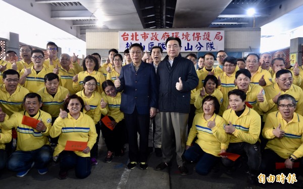 台北市長柯文哲（中左）15日除夕前往市政府環保局松山區松山分隊，發紅包慰勉同仁，並與環保局長劉銘龍（中右）及清潔隊員合影留念。（記者簡榮豐攝） 