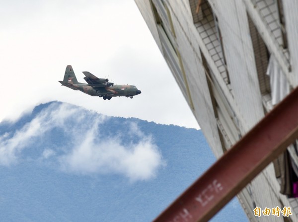 新加坡空軍C-130運輸機今天滿載救援物資抵達花蓮災區,在降落時剛好經過震災中傾倒的大樓。(記者羅沛德攝)