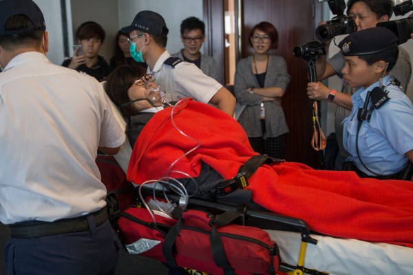 發生推擠衝突後,多名保全稱身體不適後,戴著氧氣罩、躺在擔架上被抬離現場。(歐新社)