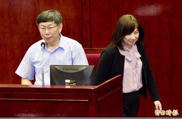 台北市長柯文哲(左)16日赴市議會進行預算案報告及答詢,民進黨決定在年底台北市長選舉啟動徵召,提出人選,民進黨籍台北市副秘書長李文英(右)隨後向台北市長柯文哲口頭請辭,兩人在議會中同時上台,答覆議員質詢。(記者羅沛德攝)