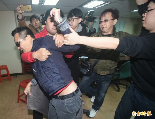 男子持生髮劑朝蔡丁貴噴灑,被阻止架離。(記者廖振輝攝)