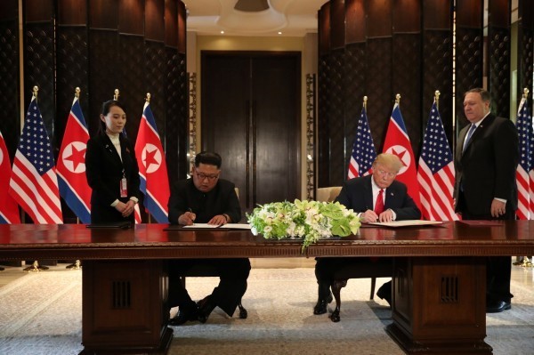 美國總統川普與北韓領導人金正恩共同簽署文件。(路透)