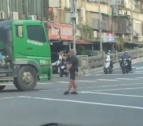 台北市內湖區舊宗路與新明路口今天出現1名男子站在十字路口指揮交通。(圖擷取自爆廢公社)