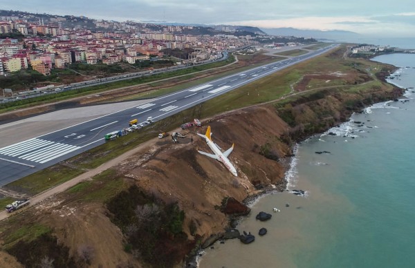 土耳其飛馬航空(Pegasus Airlines)一架客機降落疑打滑失控衝出跑道,白天環視意外現場,才發現飛機只差幾公分就要墜入黑海懸崖,可見當時驚險。(法新社)
