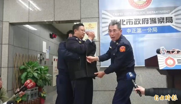 警方示範昨天以保護管束帶包覆抗議民眾。(記者王冠仁攝)