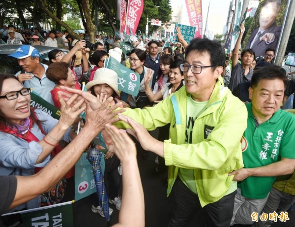 民進黨台北市長候選人姚文智下午於市府路舉辦「手護國家首都」造勢活動，一一與支持者擊掌。（記者方賓照攝）