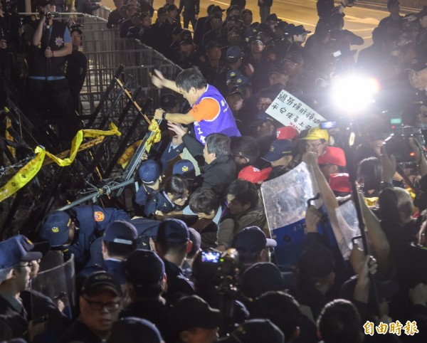 勞團遊行入夜時再爆發衝突,有民眾翻上拒馬濺血。(記者黃耀徵攝)