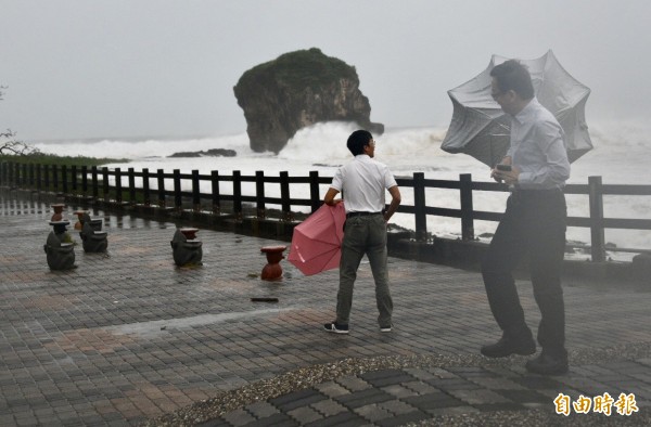 強颱「山竹」從鵝鑾鼻南方海域經過，掀起恆春半島巨浪風雨，民眾大多進入屋內躲避，唯有「勇敢」中客無懼風雨，好奇到海邊觀浪。（記者蔡宗憲攝）