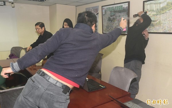 統派團體成員胡、陳、黃姓男子闖入會場,並朝自由台灣黨主席蔡丁貴狂噴生髮劑。(記者廖振輝攝)
