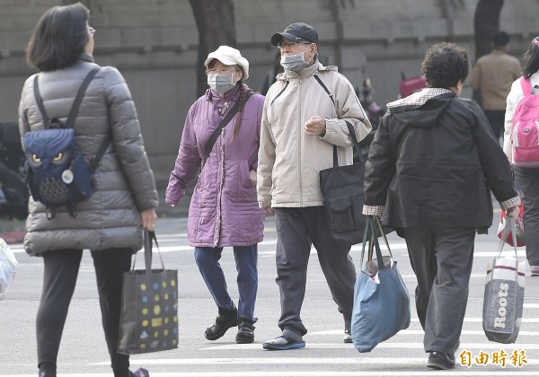 大陸冷氣團挾帶境外污染物影響北台灣，很多行人都戴上口罩。（記者陳志曲攝）