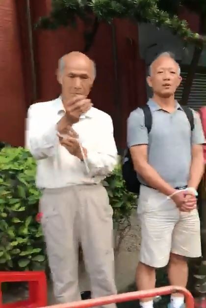 反年改成員看到鏡頭在拍,急忙把手套入束帶。(圖翻攝自臉書)