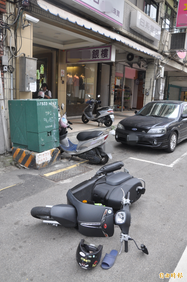 邱姓搶嫌的機車倒在銀樓門口。（記者彭健禮攝） 