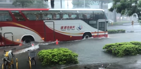 高雄前鎮區的道路上，原指引行車通行方向的交通錐，受大雨淹水影響均漂浮在道路上。（圖擷取自爆料公社）