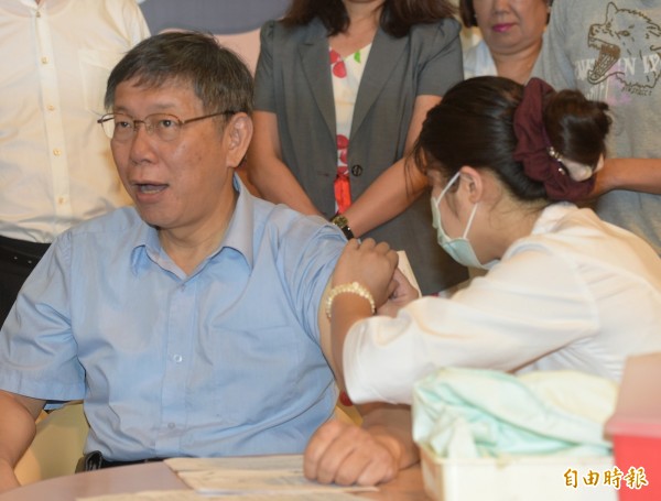 台北市長柯文哲施打流感疫苗,針扎下去時嘴巴微張,顯然有點痛。(記者張嘉明攝)