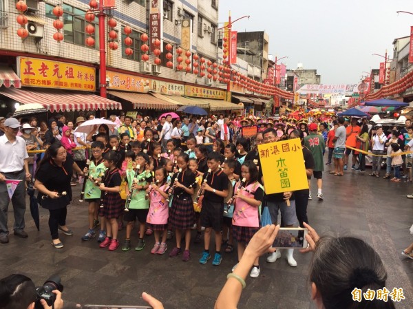 難得一見的「風雨免朝」令旗一出，下午2點前，果然雨勢暫緩，活動如願順利進行。信眾對「新港媽」神威顯赫嘖嘖稱奇。（記者陳璟民攝）