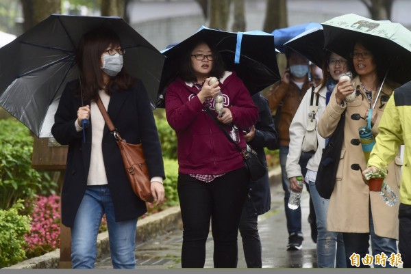 明天北部、東部及東南部地區天氣持續濕涼,提醒民眾外出記得穿暖、帶傘。(資料照)