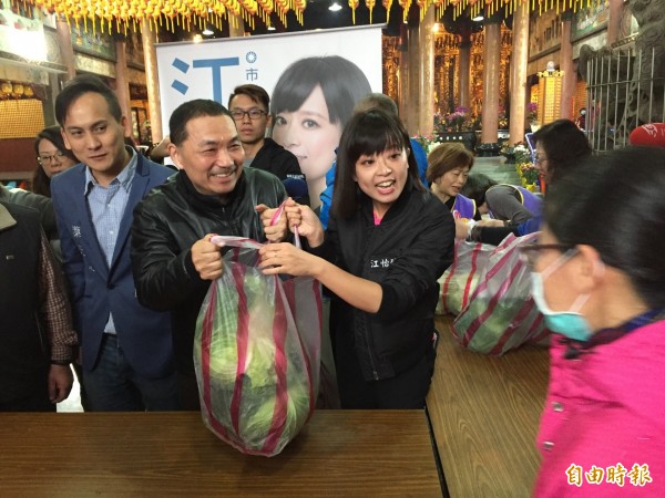 新北市前副市長侯友宜(中)與新北市議員候選人江怡臻(右)、葉元之(左)一同到場義賣高麗菜。(記者邱書昱攝)