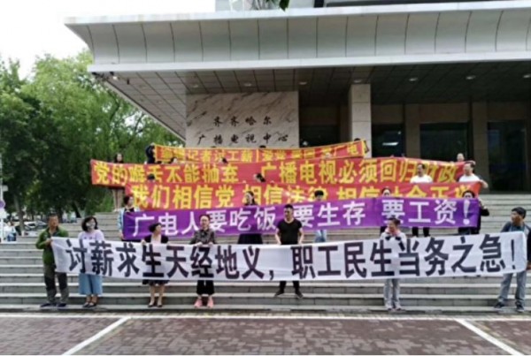 齊齊哈爾廣播電視中心編輯、記者在電視台前拉起布條討薪。(擷取自網路)