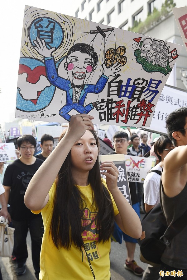 經濟部5日晚間臨時通知,將到中國舉行貨貿諮商。圖為民眾舉牌抗議貨貿談判。(資料照,記者陳志曲攝)