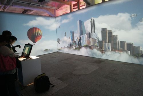 在Windows 8 狂想世界特展中,民眾拍下自己照片後,透過人機互動介面,身影立即與動態牆上各種奇幻背景融合,還能透過現場電腦將合成照上傳臉書。