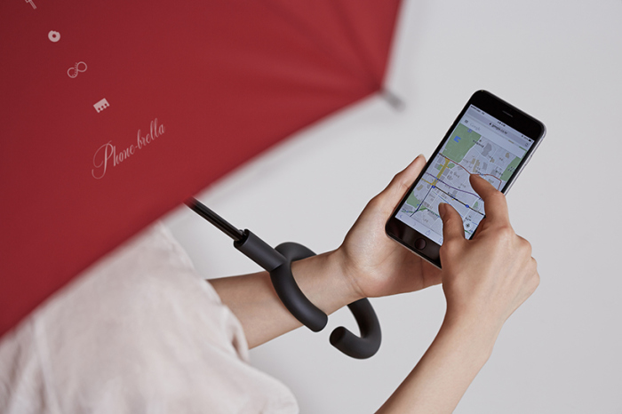 這款 Phone-brella 特殊的地方就是 C 形手把設計,讓你可以將雨傘輕鬆地掛在手腕上並讓傘柄靠著肩膀,不用讓手拿著傘(圖片來源/截自影片)
