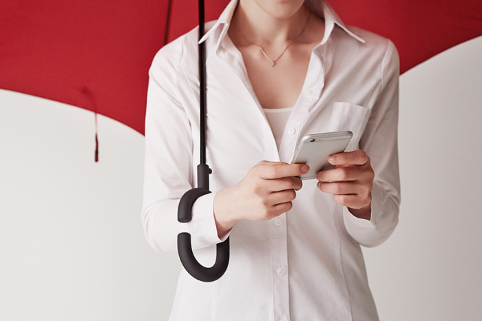 為了讓客戶能在雨天飆網無極限,韓國電信公司旗下的 KT Design 就發明了一款Phone-brella 只要將傘套在手腕上,就能讓低頭族盡情玩手機。(圖片來源/截自影片)
