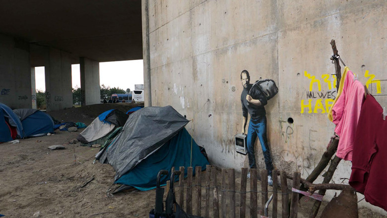 藝術家 Banksy 希望透過賈伯斯的移民之子身分,喚起大家對難民議題的關注(圖/Banksy)