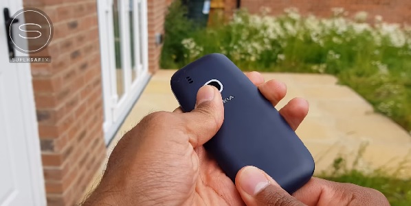 把新版 Nokia 3310 從2層樓高的窗戶往地面摔落,結果僅機殼略有鬆開,把背蓋壓緊,開機後,依然能正常使用,機身與螢幕都近乎毫髮無傷。(圖/擷取自《SuperSaf TV》影片)