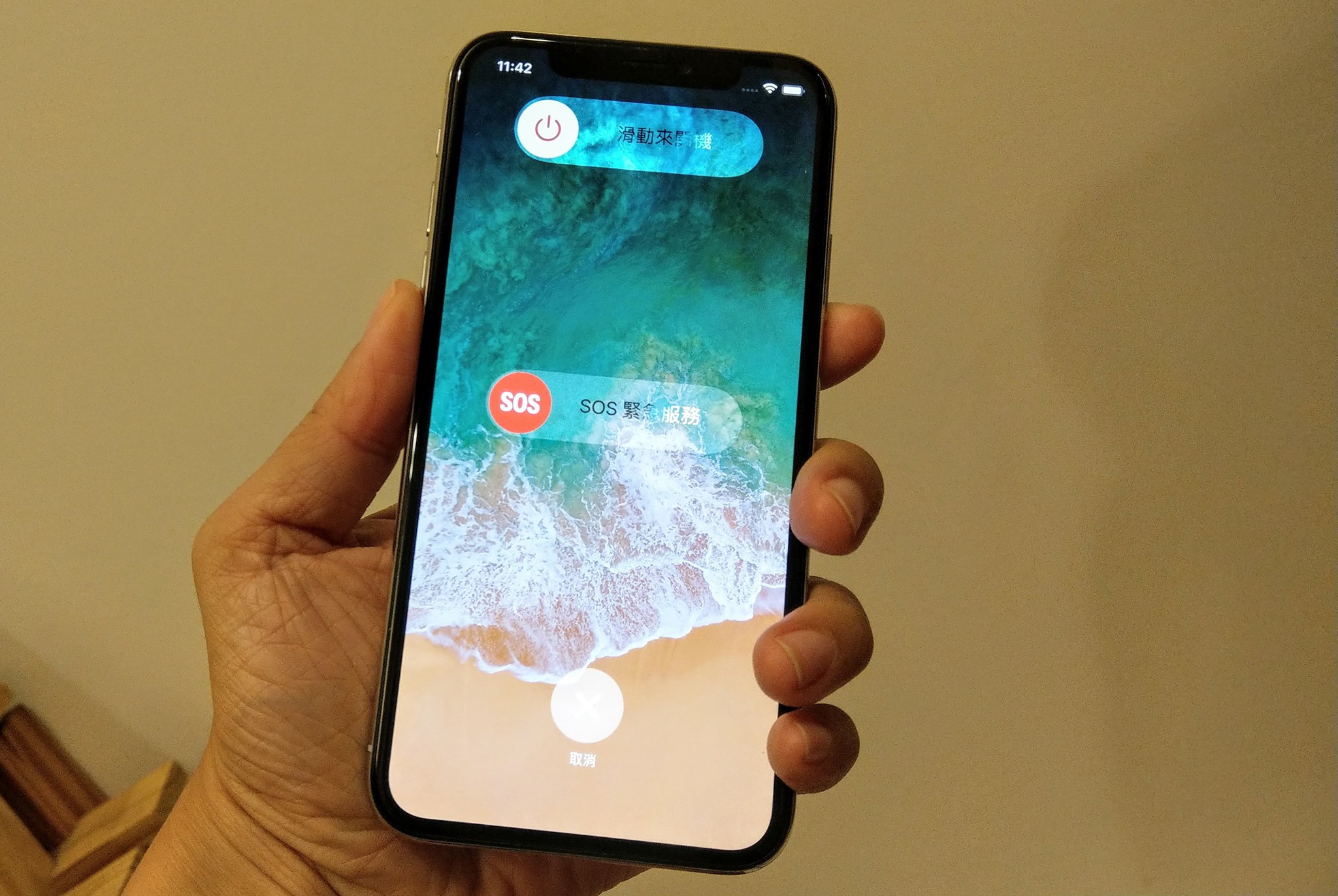 同時按住電源鍵與增加音量鍵，約2秒，按下滑動關機按鈕，即可把iPhone X 關機。(圖記者劉惠琴攝)