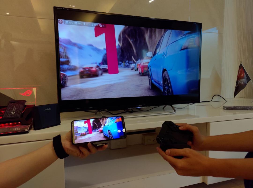 透過WiFi與遊戲搖桿手把主機連接後，在家投放到大螢幕電視後，就能用搖桿操控。(圖／記者劉惠琴攝）