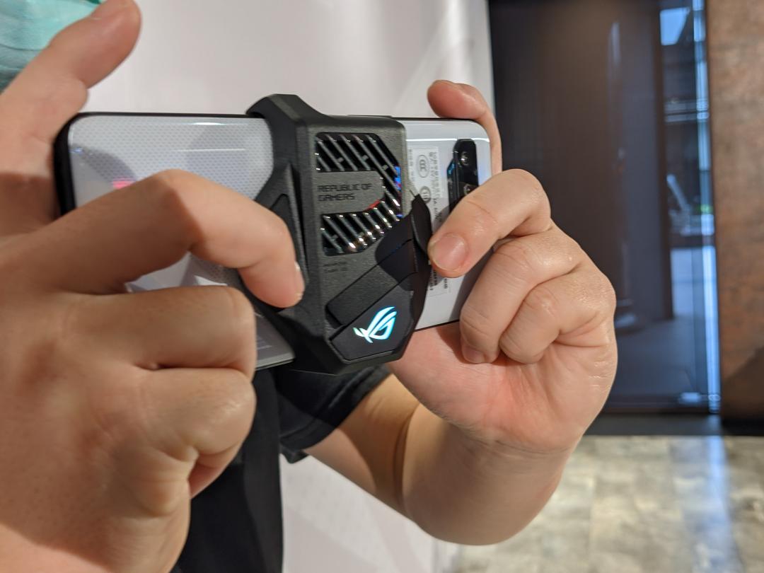 ROG Phone 5隨機附贈的外掛風扇配件,這次新增兩個實體按鍵的設計,可支援遊戲操控功能。(圖/記者劉惠琴攝)