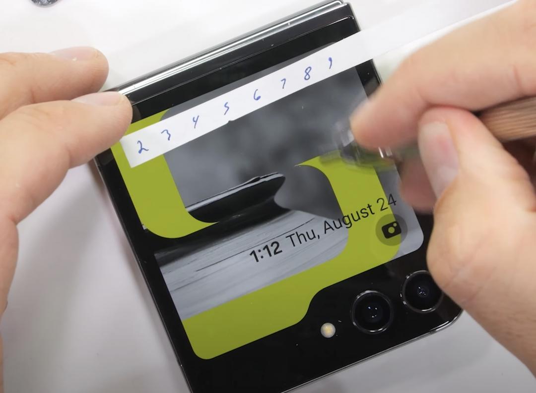 用刀片刮外螢幕，擁有不錯的硬度表現。（圖／翻攝YT）