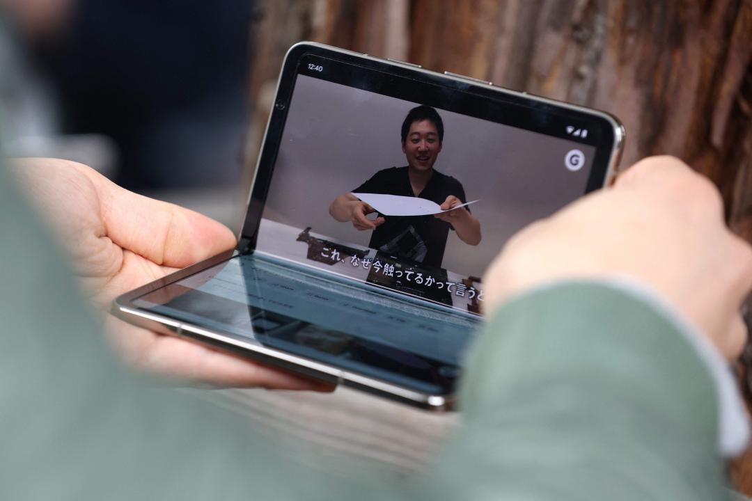 透過彎摺成L型，也讓手機就像自帶支架，延伸出更多情境的用法。（法新社）