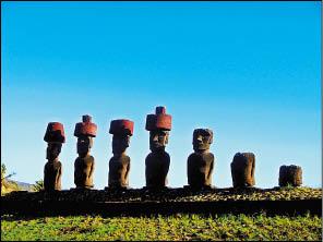 藍天下戴著可愛紅色圓帽的Moai排排站，部分已傾圮。