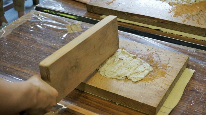 體驗和紙製作的遊客正在敲打造紙纖維。（榮青攝）