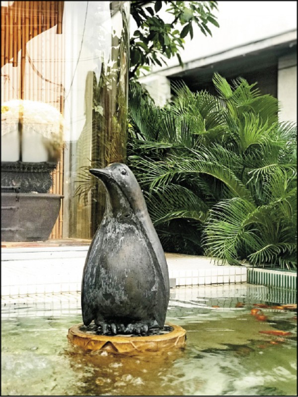 直島錢湯門口的水池中，豎立一座企鵝雕像。
