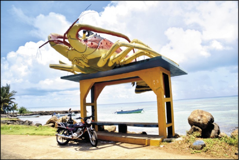 盤踞在候車亭上的大隻龍蝦，突顯玉米島盛產龍蝦的特色。