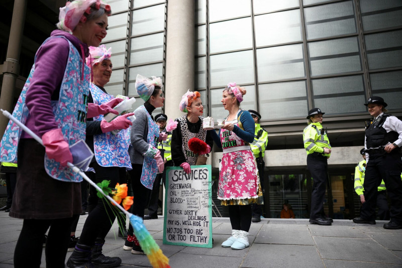 4 月 12 日，反抗滅絶行為藝術表演者打扮成家事勞動者訴求環保議題。（路透社）
