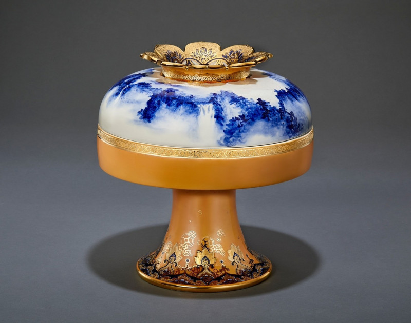 〈銀鍊飛淵〉，器型參考來自秦時期的食器和禮器。使用瓷土、青花釉料、橘色釉料、黃金，可做為聚寶罐使用。（卓麗秋／提供）