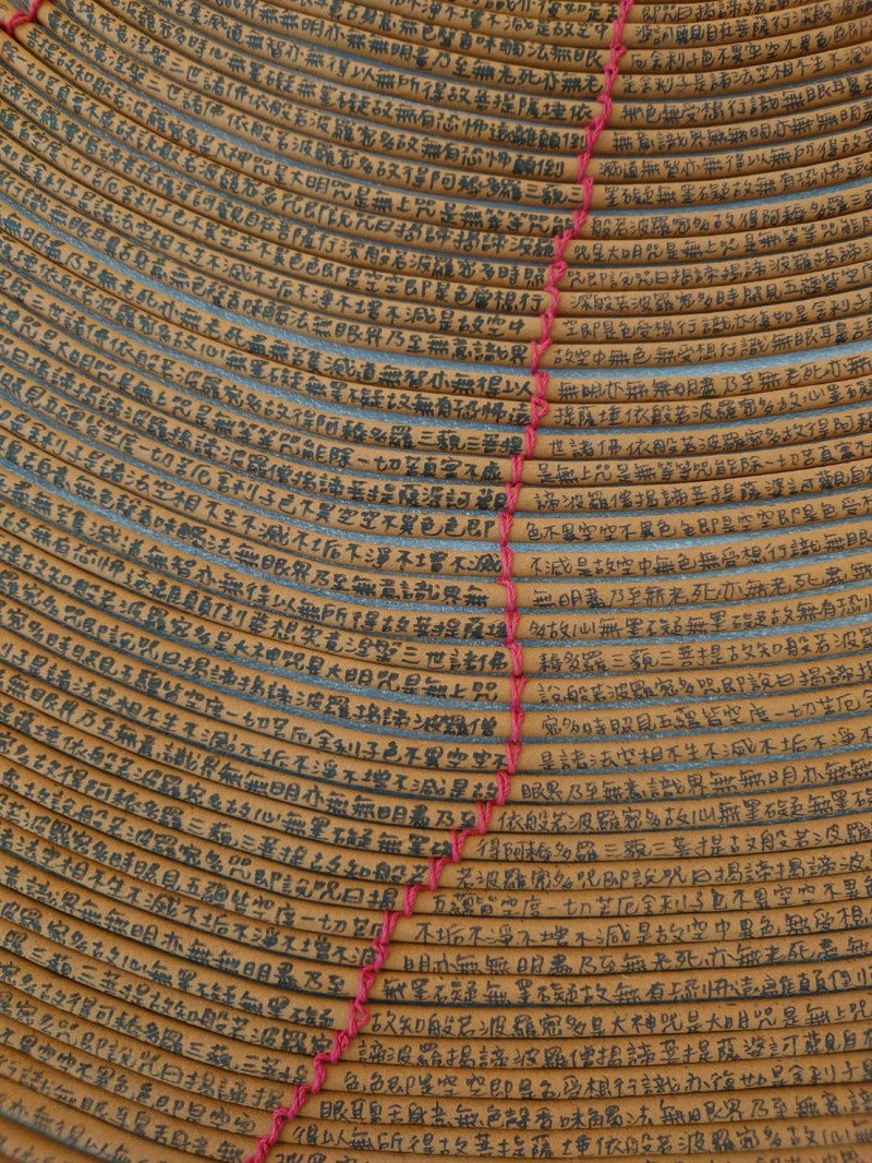 台南市美術館「亞洲的地獄與幽魂」布展​中，圖為蔡佳葳 作品《香環咒》 2014 裝置手寫於香環上各150公分。　（南美館提供）